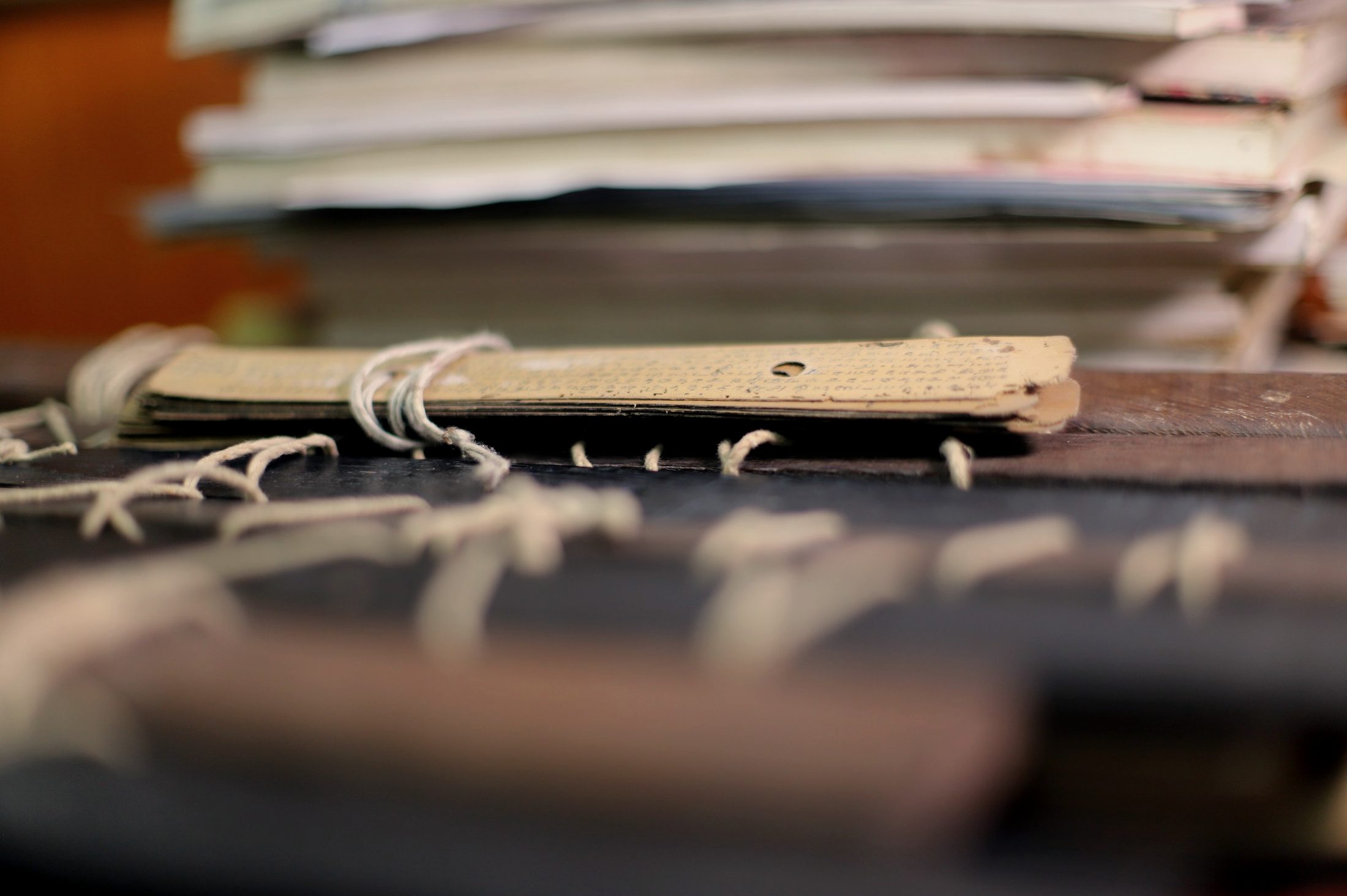 A single inscribed palm leaf resting on a bound bundle