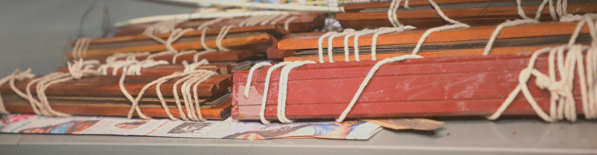 Palm-leaf bundles tied with cord on the library shelves
