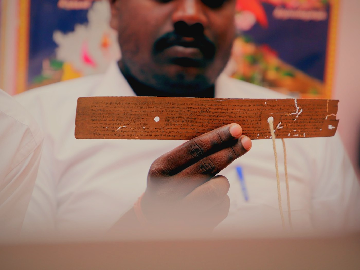 A reader holding a single inscribed leaf